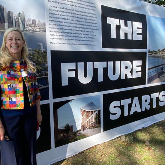 Maurie McInnis in front of the governors island sign