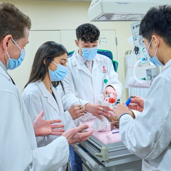group of med students practicing on doll