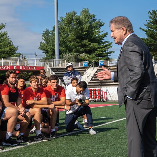 president speaking with athletes