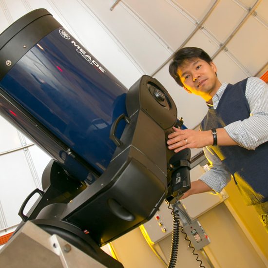 Astronomer Jin Koda in front of huge telescope
