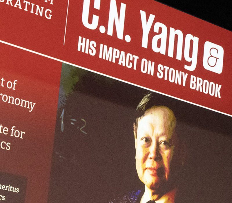 A close-up image of a presentation slide featuring C.N. Yang. The slide highlights his impact on Stony Brook University, including references to his work in physics and his association with the university. His photo is in the center, with text on a red background.